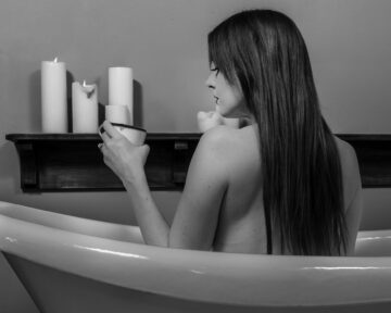 Creative studio portrait of Kate with a vintage bathtub prop and artistic lighting effects
