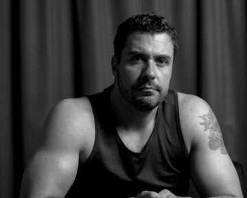High-contrast black and white studio portrait of Mark with artistic shadows and professional lighting
