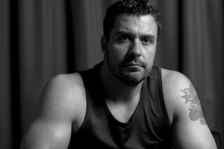 High-contrast black and white studio portrait of Mark with artistic shadows and professional lighting