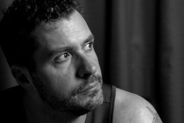 Professional black and white studio portrait of Mark with creative lighting and high contrast photography