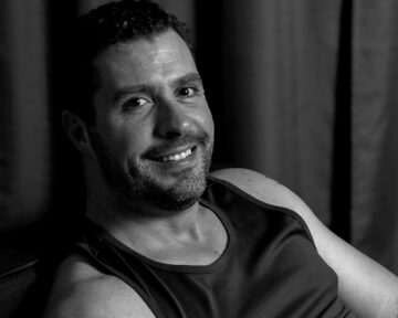 Dramatic black and white studio portrait of Mark with high contrast lighting and artistic shadows
