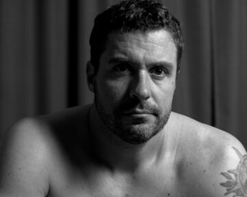 Professional black and white studio portrait of Mark with high contrast lighting and artistic composition