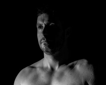 Classic black and white studio portrait of Mark with high contrast lighting and professional composition